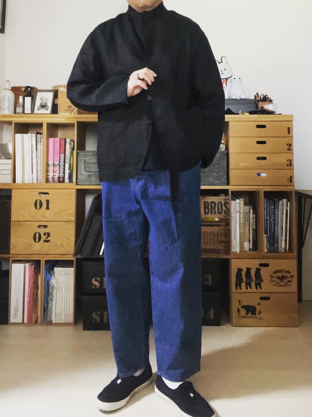 ブラック系のテーラードジャケット、ブルー系のデニムパンツ、ブラック系のスニーカーを着用したメンズの春コーディネートの2枚目の写真