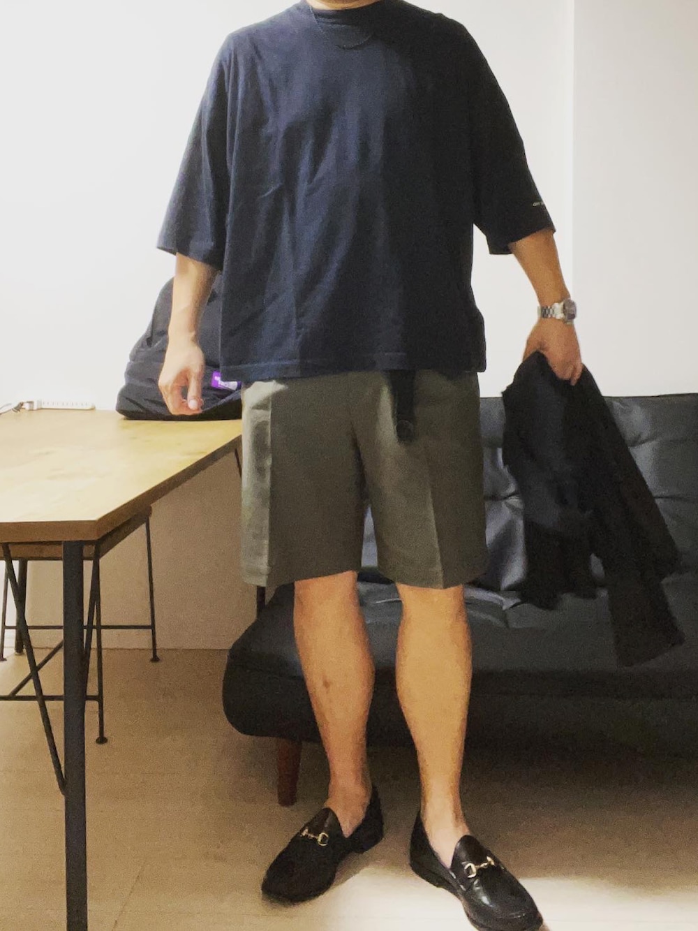 ブラック系のシャツ/ブラウス、グリーン系のスラックス、ブラック系のローファーを着用したメンズの春コーディネートの2枚目の写真