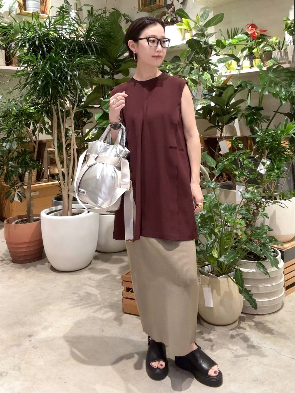 グリーン系のスカート、シルバー系のトートバッグ、ブラック系のサンダルを着用したレディースの夏コーディネートの4枚目の写真