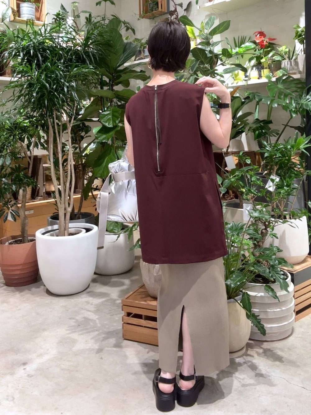 グリーン系のスカート、シルバー系のトートバッグ、ブラック系のサンダルを着用したレディースの夏コーディネートの3枚目の写真