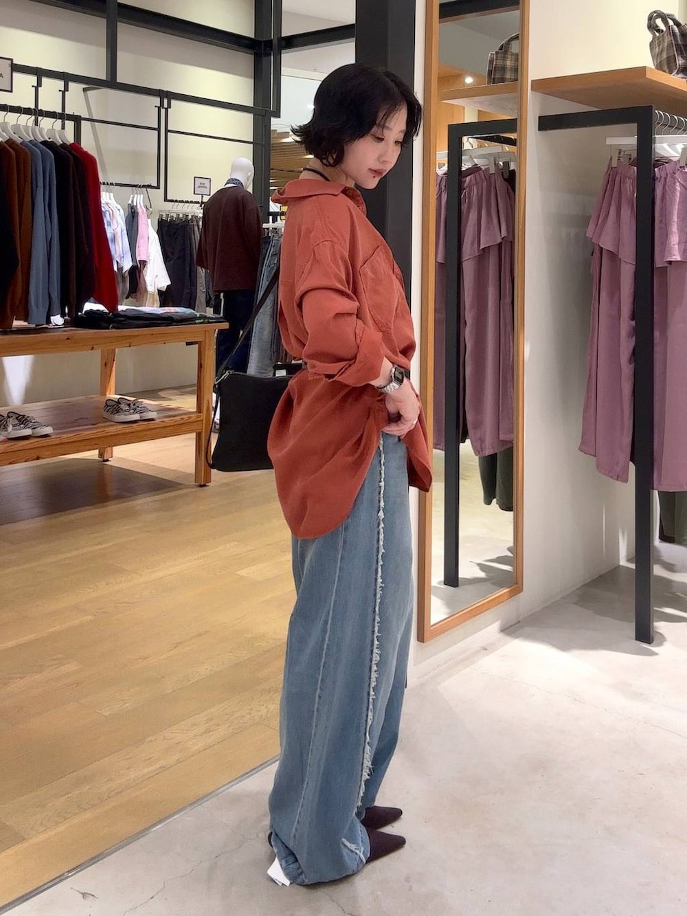 ブラウン系のパンプス、ブルー系のデニムパンツ、ブラウン系のシャツ/ブラウスを着用したレディースの夏コーディネートの3枚目の写真