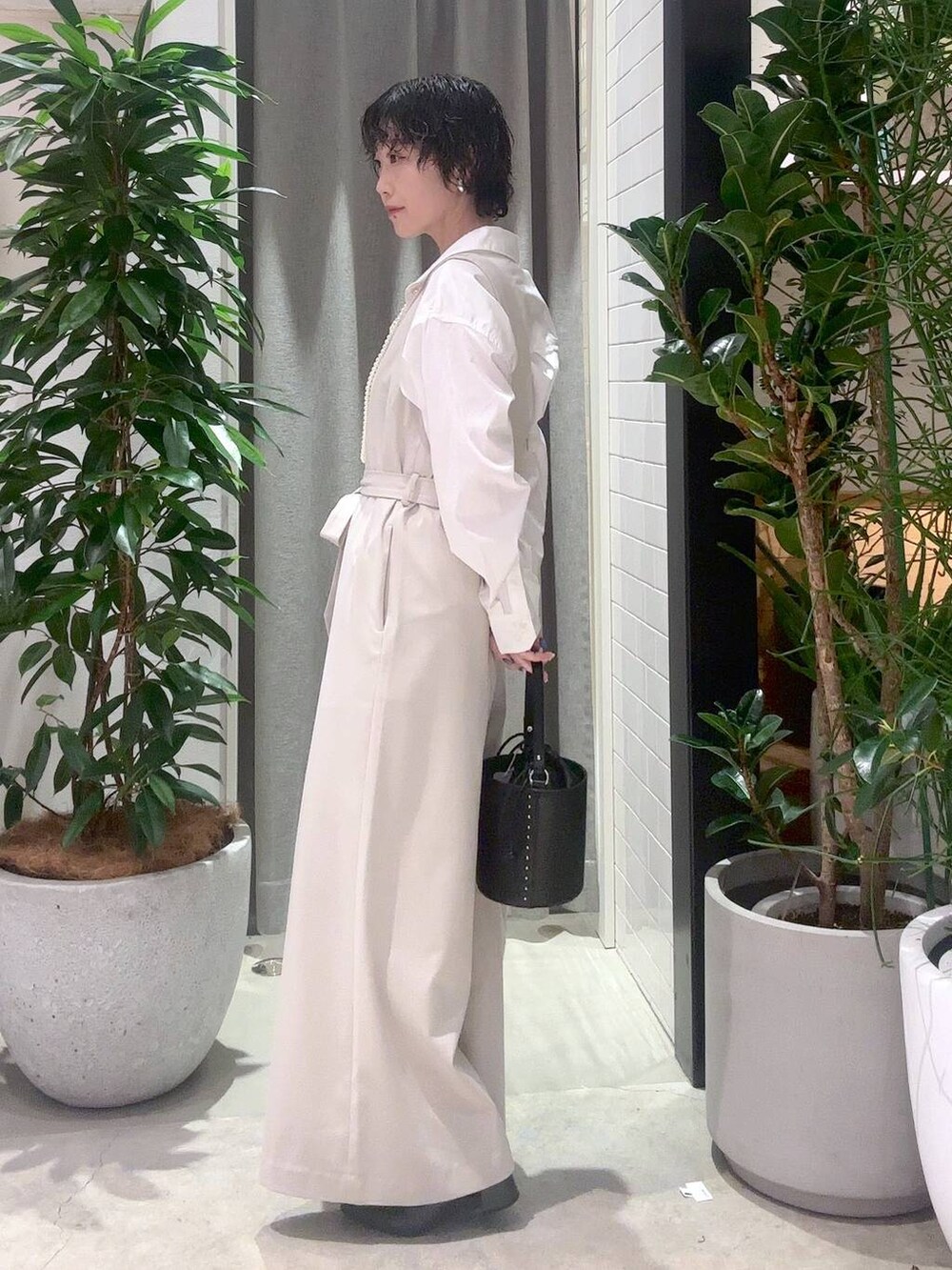 ブラック系のハンドバッグ、ベージュ系のつなぎ/オールインワン、ホワイト系のシャツ/ブラウスを着用したレディースの冬コーディネートの2枚目の写真