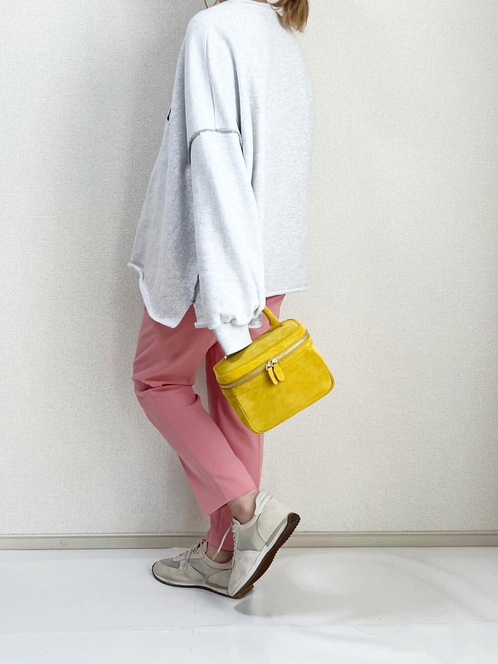 ホワイト系のスニーカー、イエロー系のバッグを着用したレディースの冬コーディネートの3枚目の写真