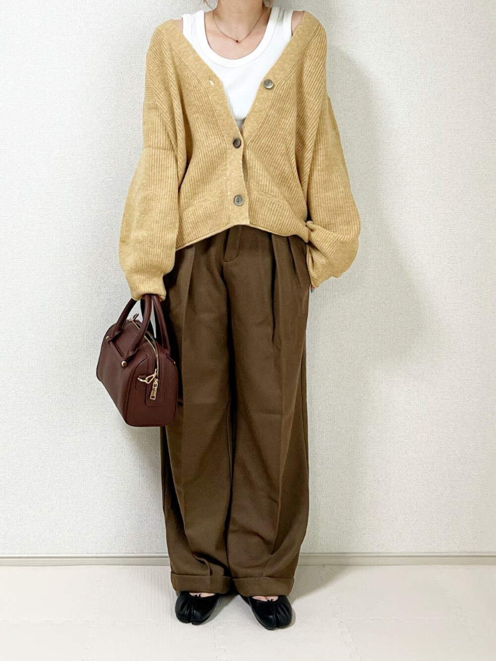 ブラック系のハンドバッグ、ブラック系のバレエシューズを着用したレディースの秋コーディネートの2枚目の写真