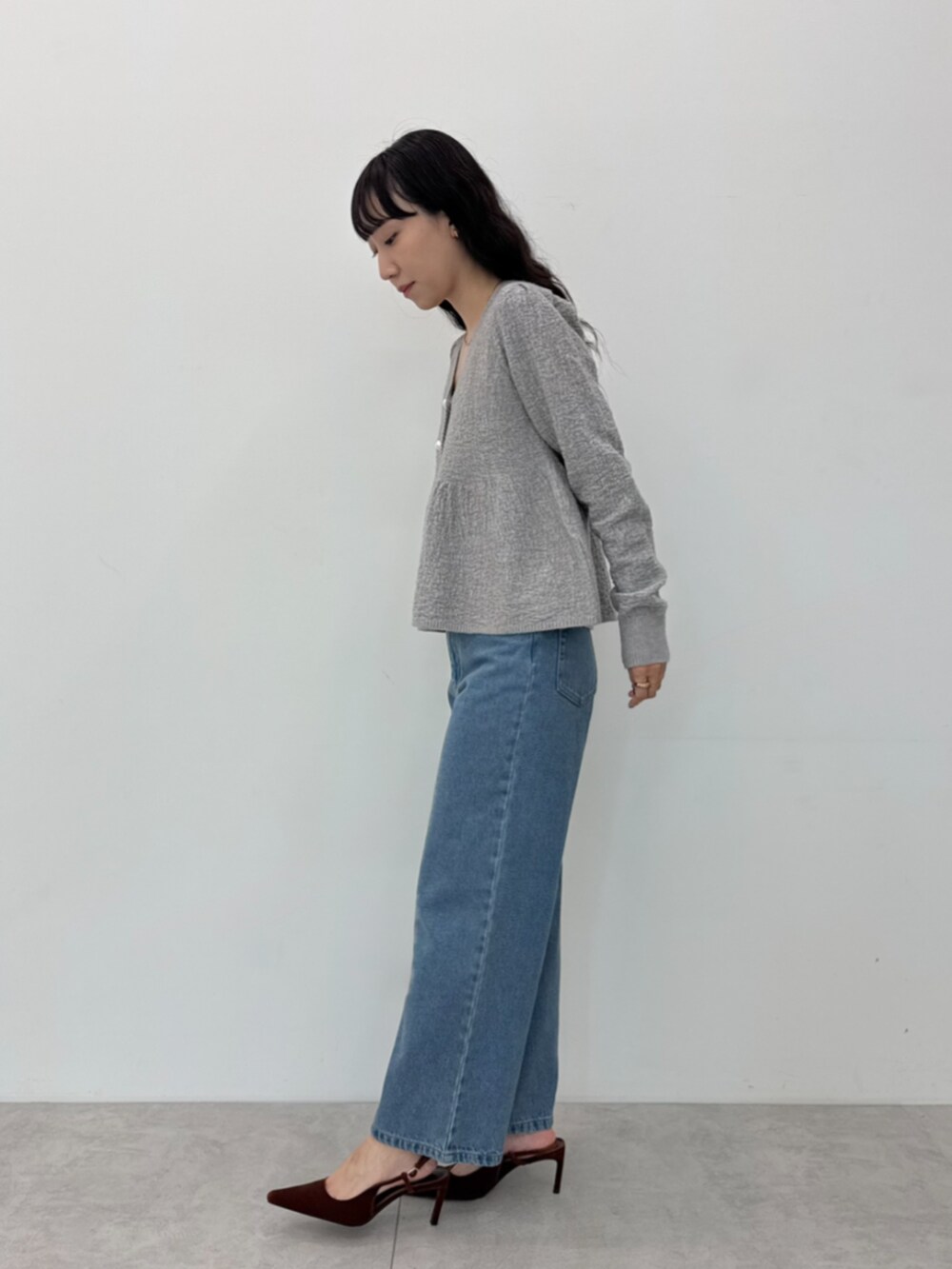 ブルー系のデニムパンツ、グレー系のカーディガン/ボレロを着用したレディースの秋コーディネートの2枚目の写真