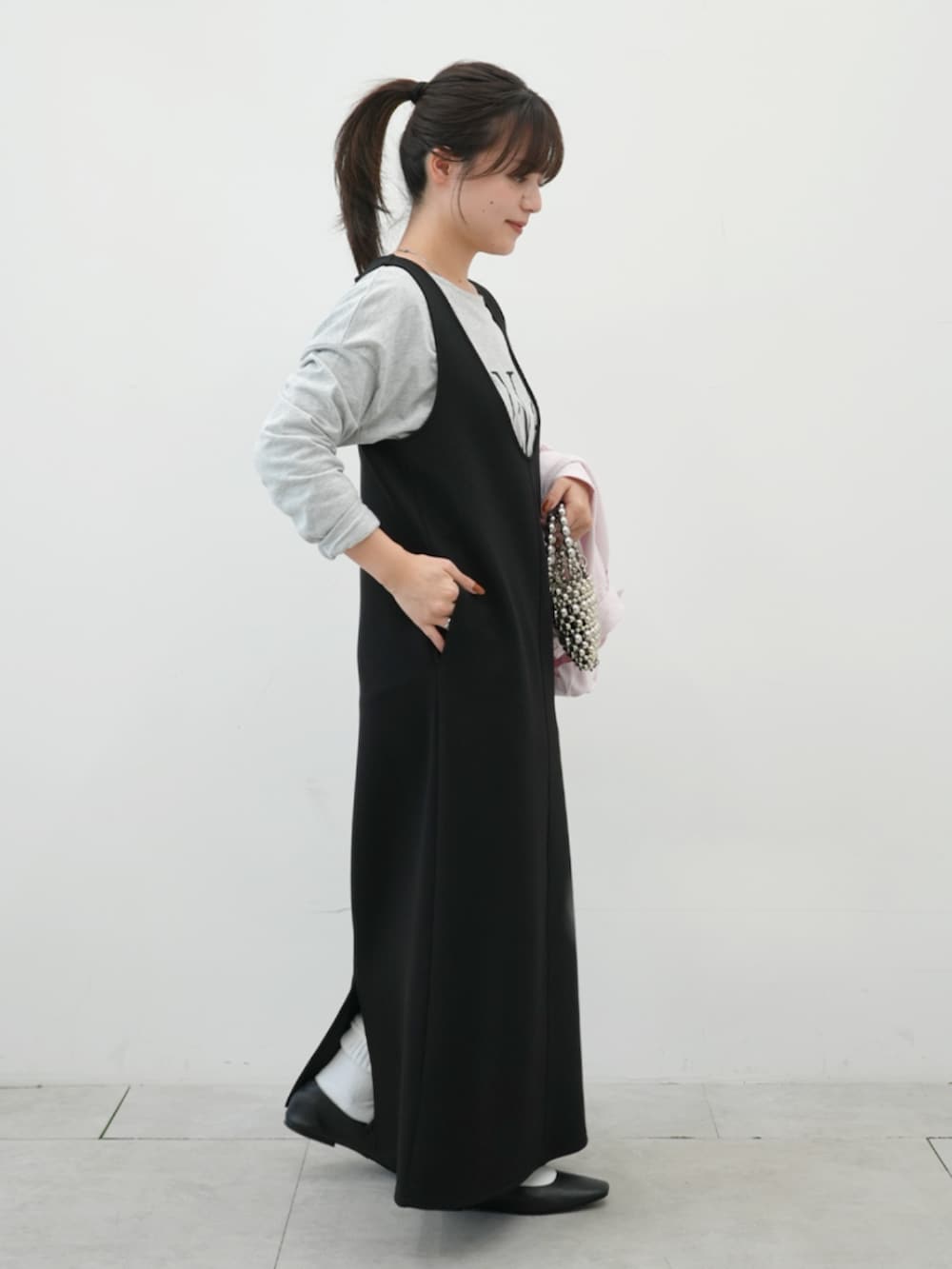 ブラック系のジャンパースカート、グレー系のTシャツ/カットソーを着用したレディースの冬コーディネートの4枚目の写真