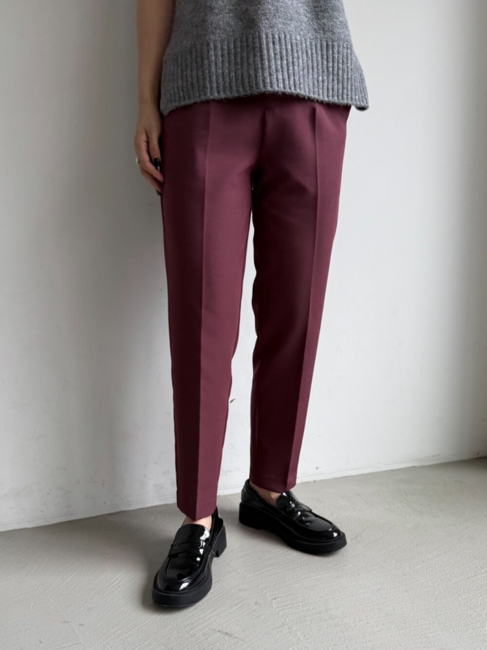 レッド系のスラックスを着用したレディースの夏コーディネートの2枚目の写真