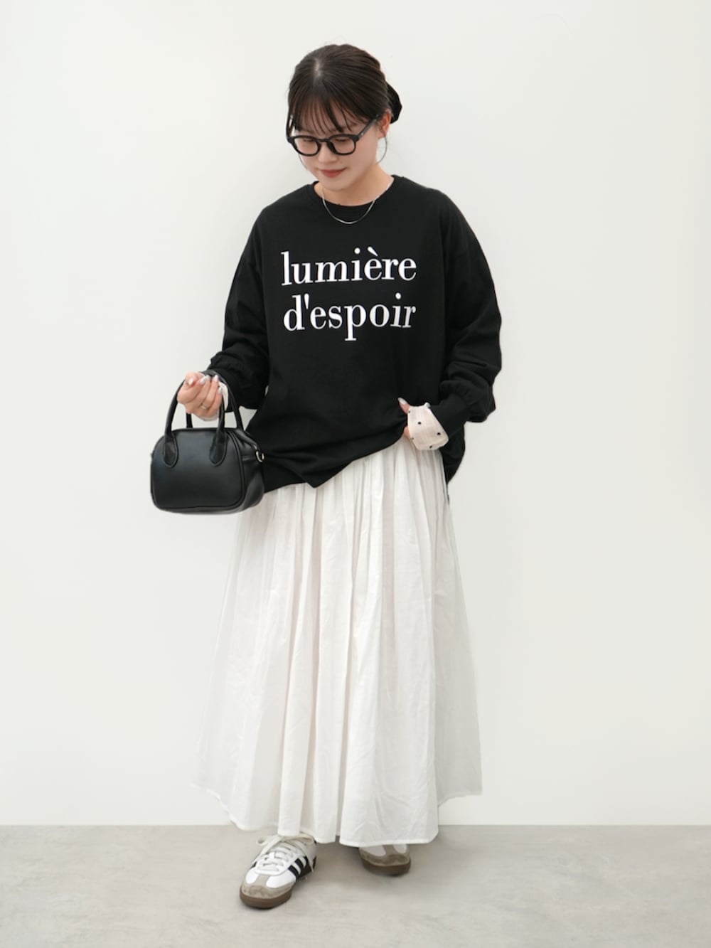 ブラック系のTシャツ/カットソー、ホワイト系のスカートを着用したレディースの春コーディネートの2枚目の写真