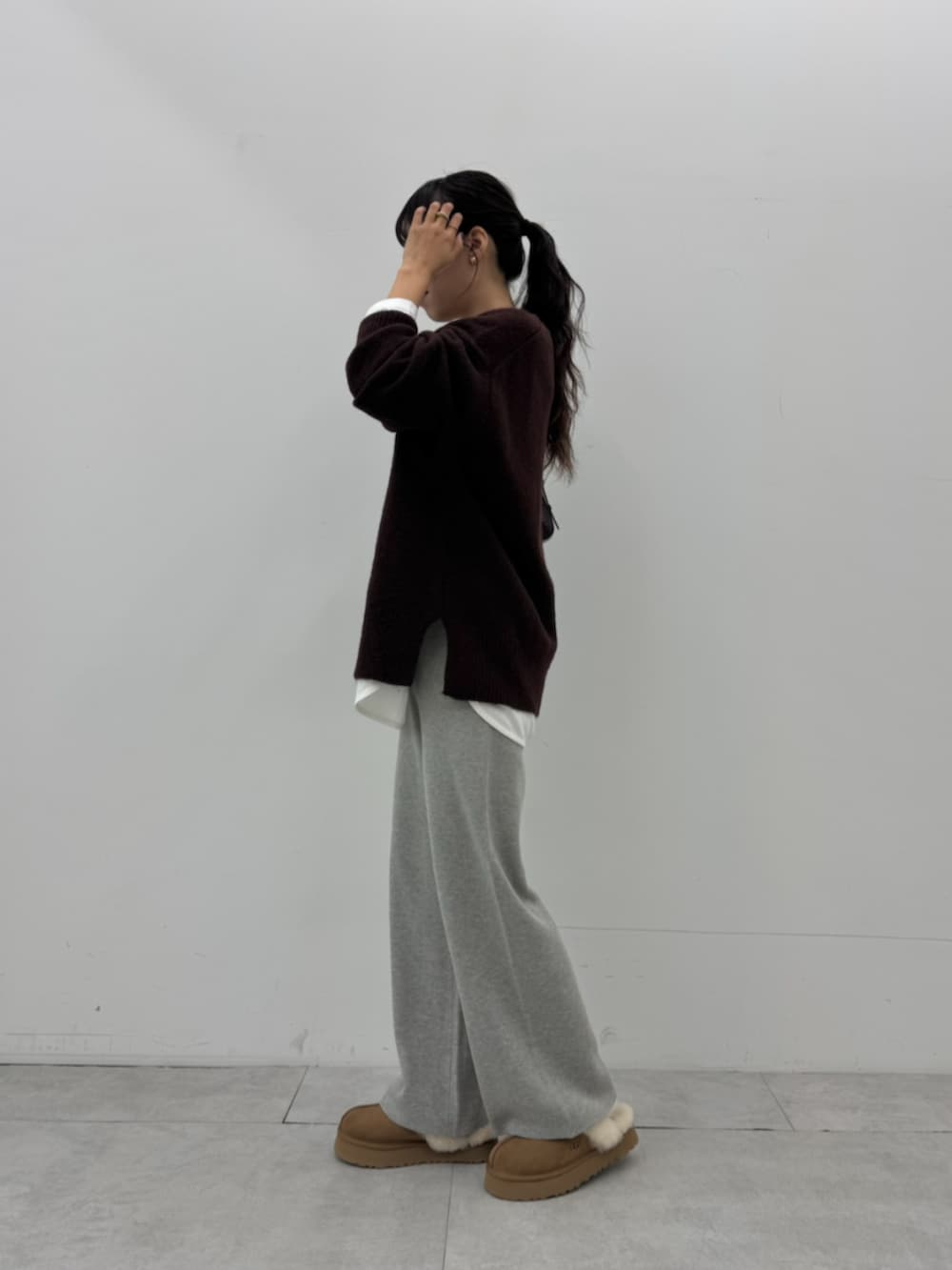 ホワイト系のTシャツ/カットソー、ブラウン系のニット/セーター、グレー系のその他パンツを着用したレディースの秋コーディネートの2枚目の写真