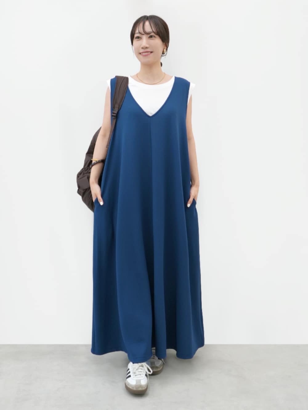 ブルー系のジャンパースカート、ブラック系のタンクトップを着用したレディースの夏コーディネートの4枚目の写真