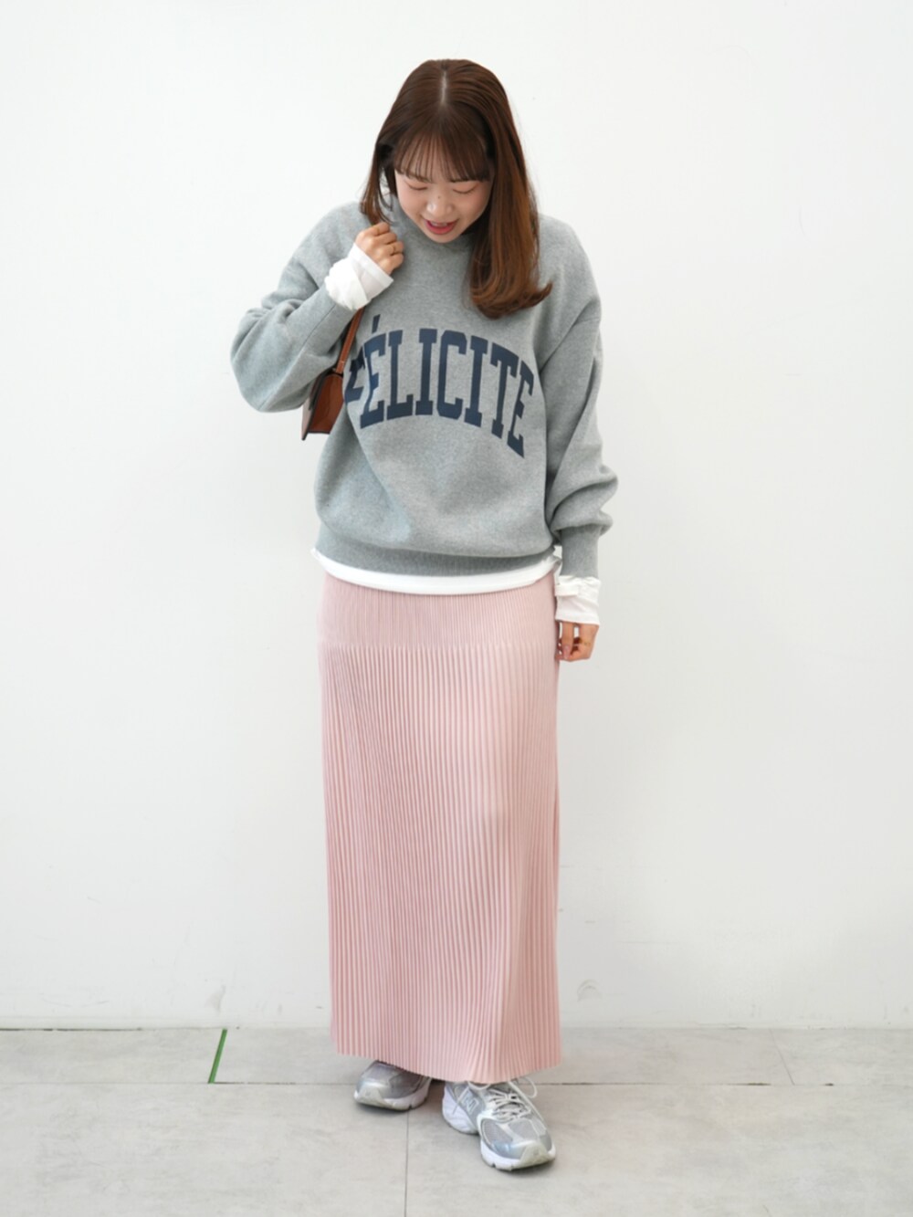 グレー系のニット/セーター、ピンク系のスカート、ホワイト系のTシャツ/カットソーを着用したレディースの冬コーディネートの2枚目の写真