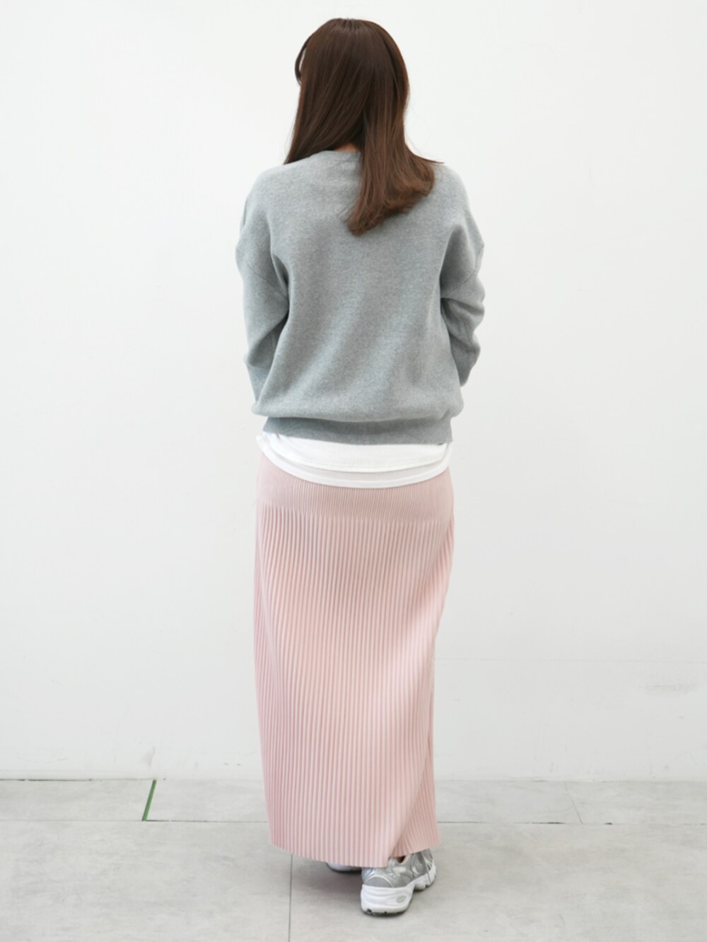 グレー系のニット/セーター、ピンク系のスカート、ホワイト系のTシャツ/カットソーを着用したレディースの冬コーディネートの3枚目の写真