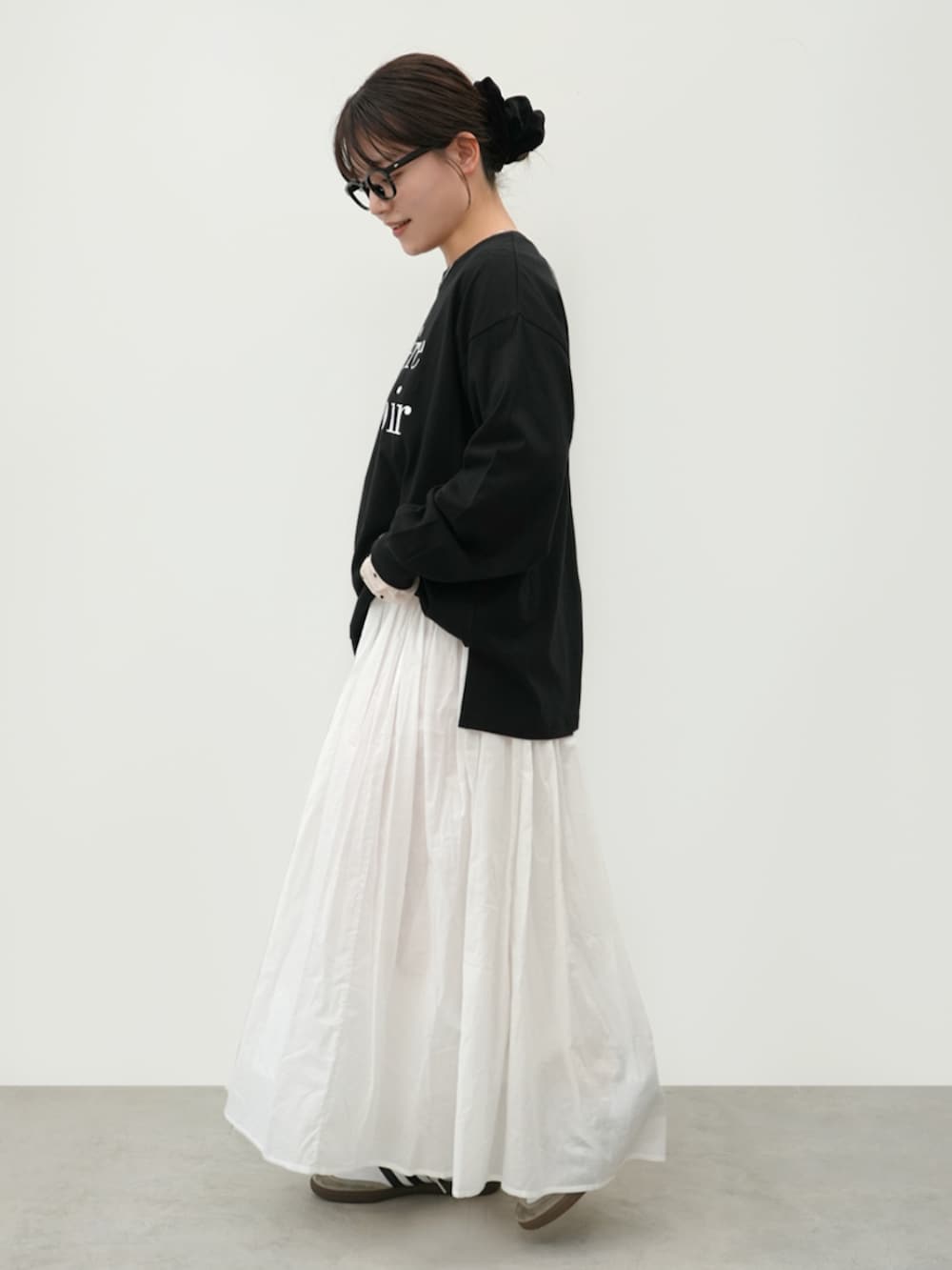 ブラック系のTシャツ/カットソー、ホワイト系のスカートを着用したレディースの春コーディネートの3枚目の写真