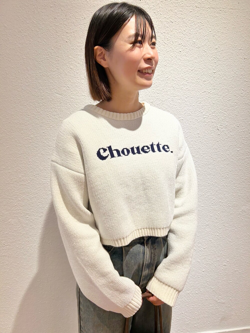 ホワイト系のニット/セーター、ブルー系のデニムパンツを着用したレディースの冬コーディネートの2枚目の写真