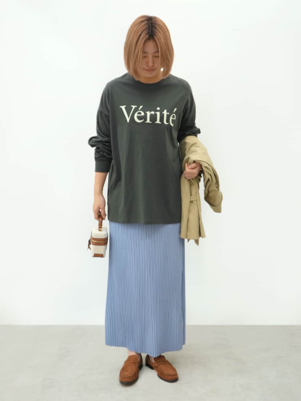 グレー系のTシャツ/カットソー、ブルー系のスカート、ベージュ系のトレンチコートを着用したレディースの春コーディネートの2枚目の写真