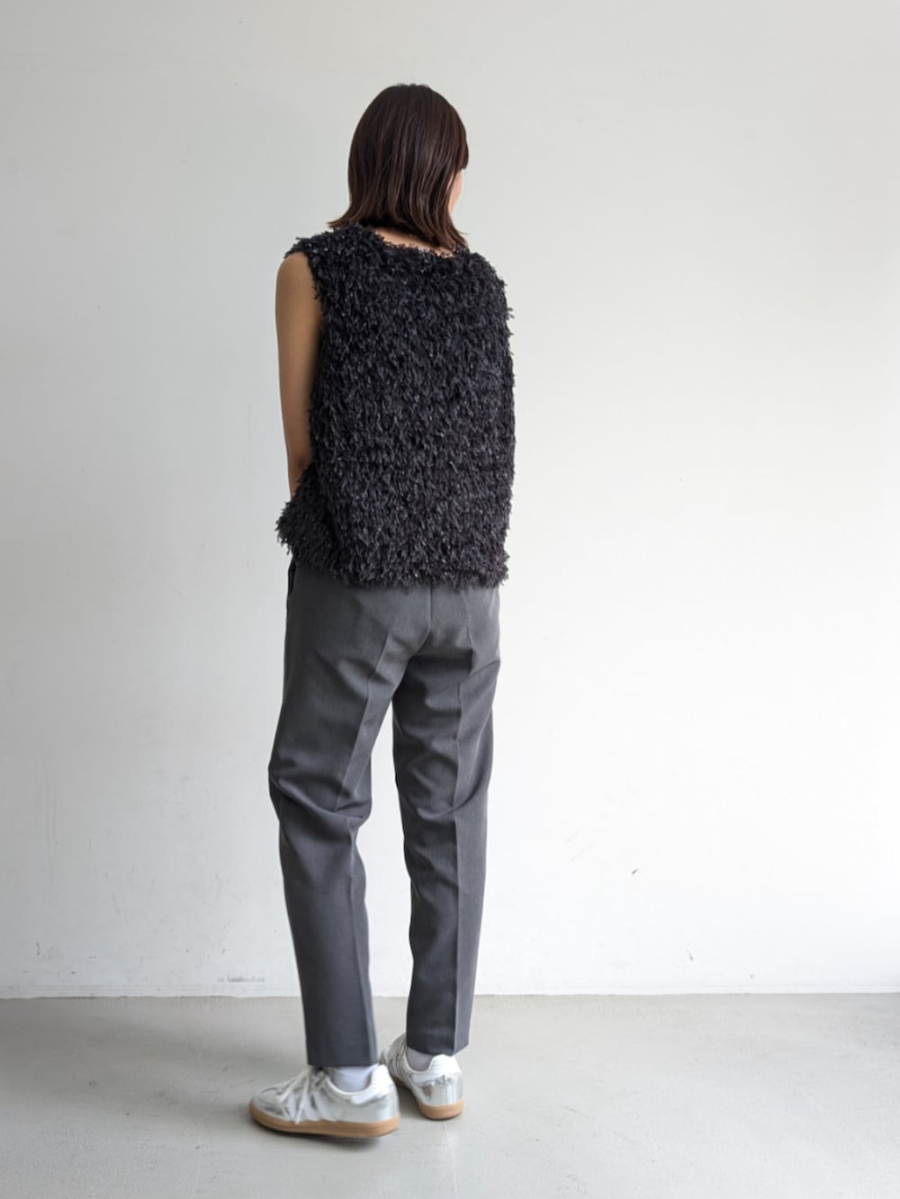 グレー系のベスト、グレー系のスラックスを着用したレディースの夏コーディネートの2枚目の写真