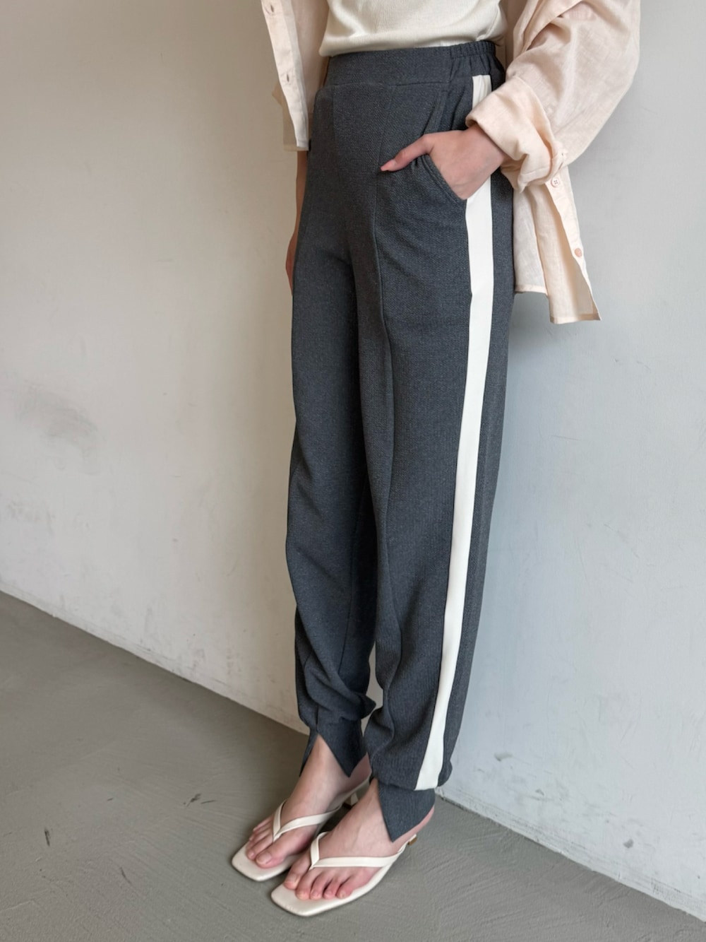 グレー系のその他パンツ、ピンク系のシャツ/ブラウス、ベージュ系のタンクトップを着用したレディースの春コーディネートの3枚目の写真