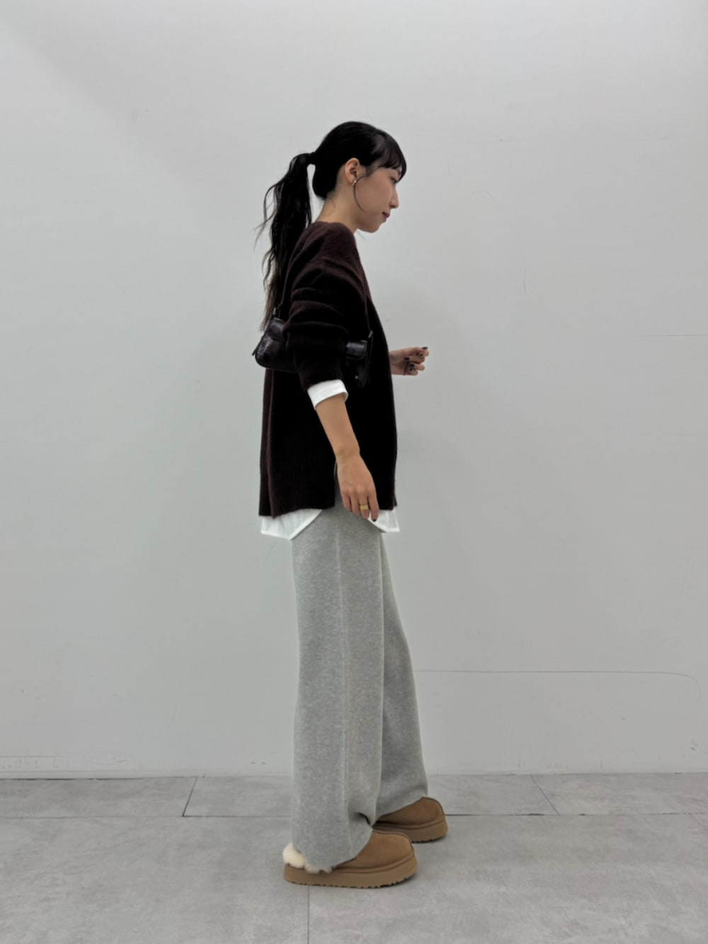 ホワイト系のTシャツ/カットソー、ブラウン系のニット/セーター、グレー系のその他パンツを着用したレディースの秋コーディネートの3枚目の写真