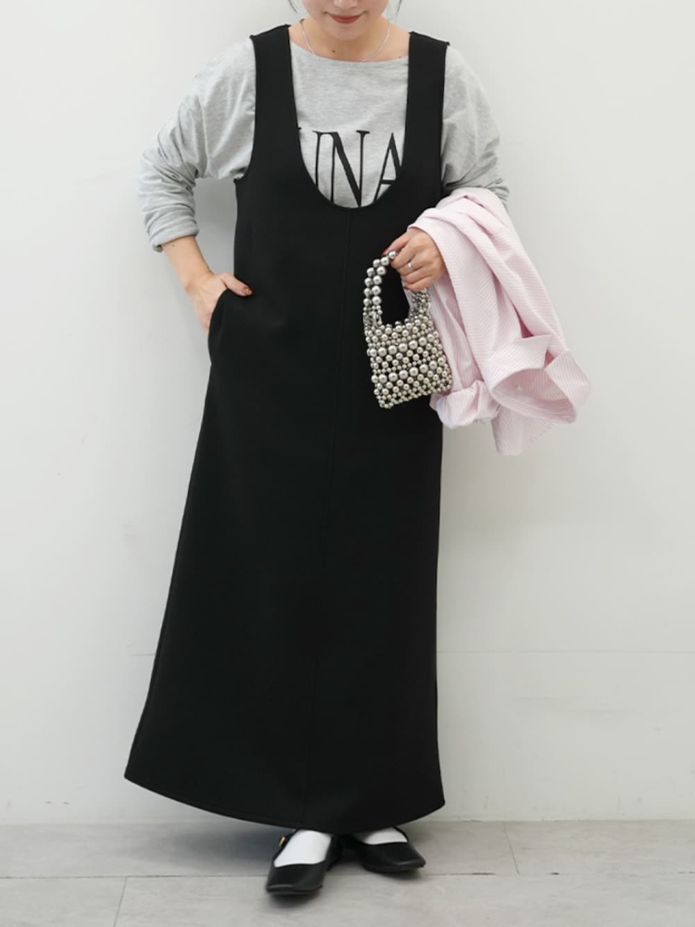 ブラック系のジャンパースカート、グレー系のTシャツ/カットソーを着用したレディースの冬コーディネートの3枚目の写真