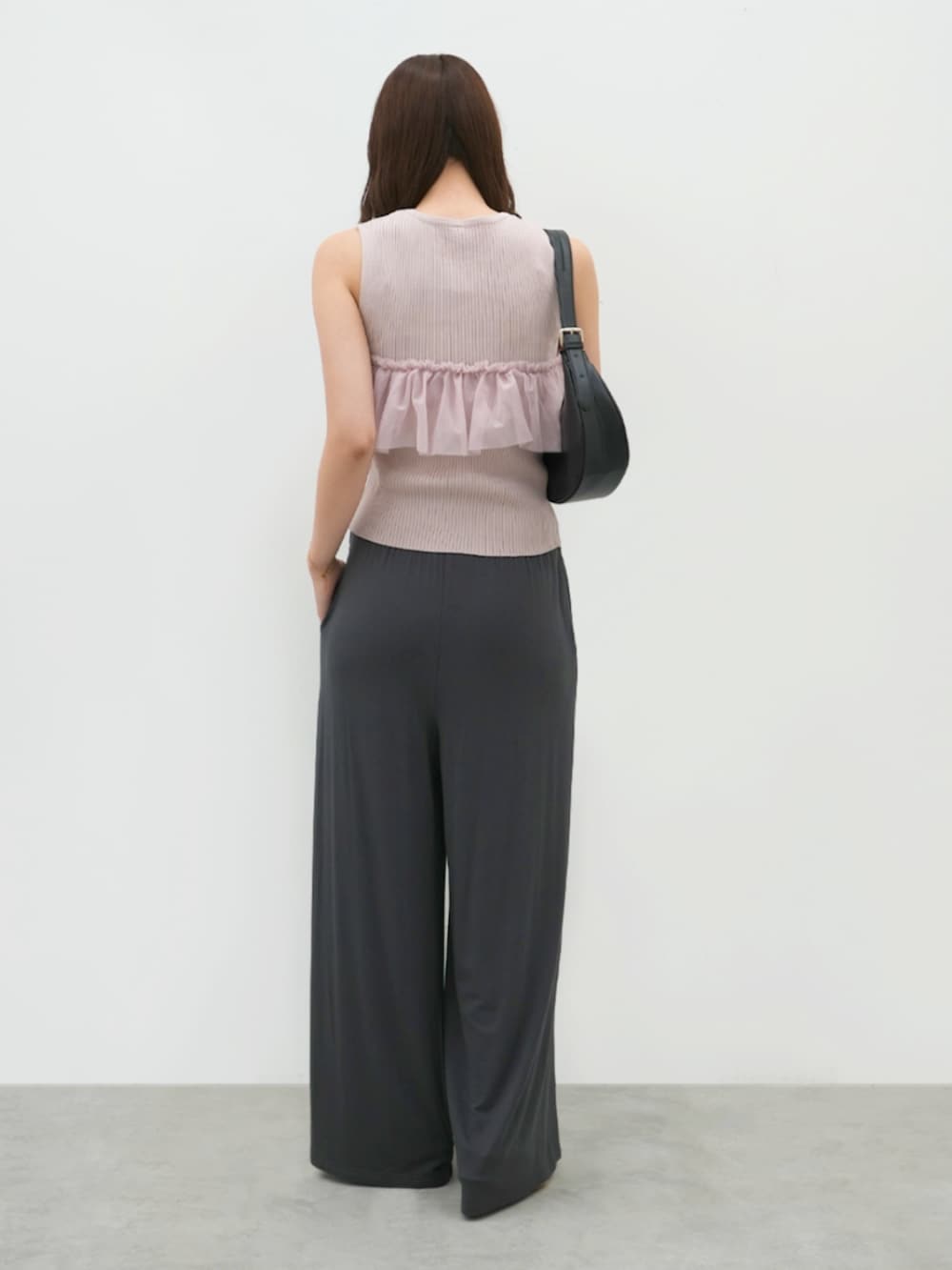 グレー系のその他パンツ、ピンク系のニット/セーターを着用したレディースの夏コーディネートの2枚目の写真