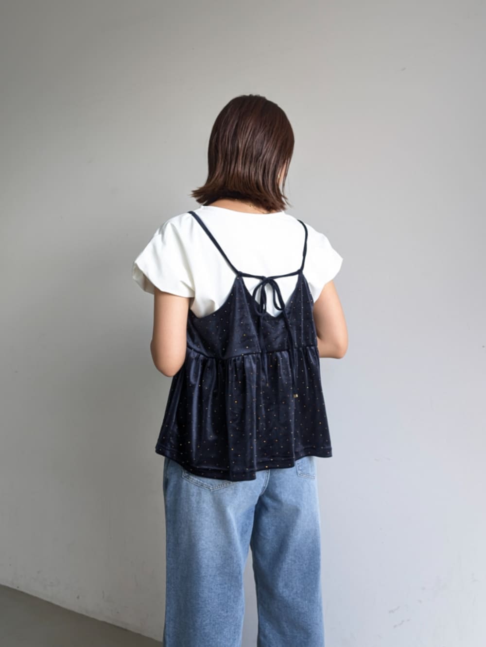 ブルー系のキャミソール、ホワイト系のTシャツ/カットソー、ブルー系のデニムパンツを着用したレディースの夏コーディネートの2枚目の写真