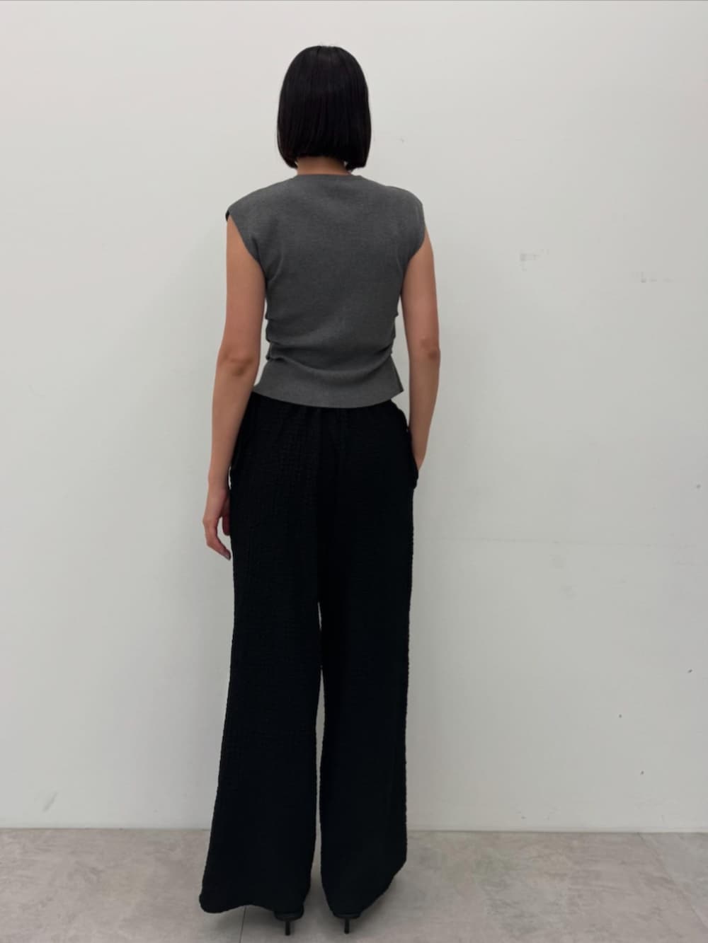 グレー系のニット/セーター、ブラック系のその他パンツを着用したレディースの夏コーディネートの2枚目の写真