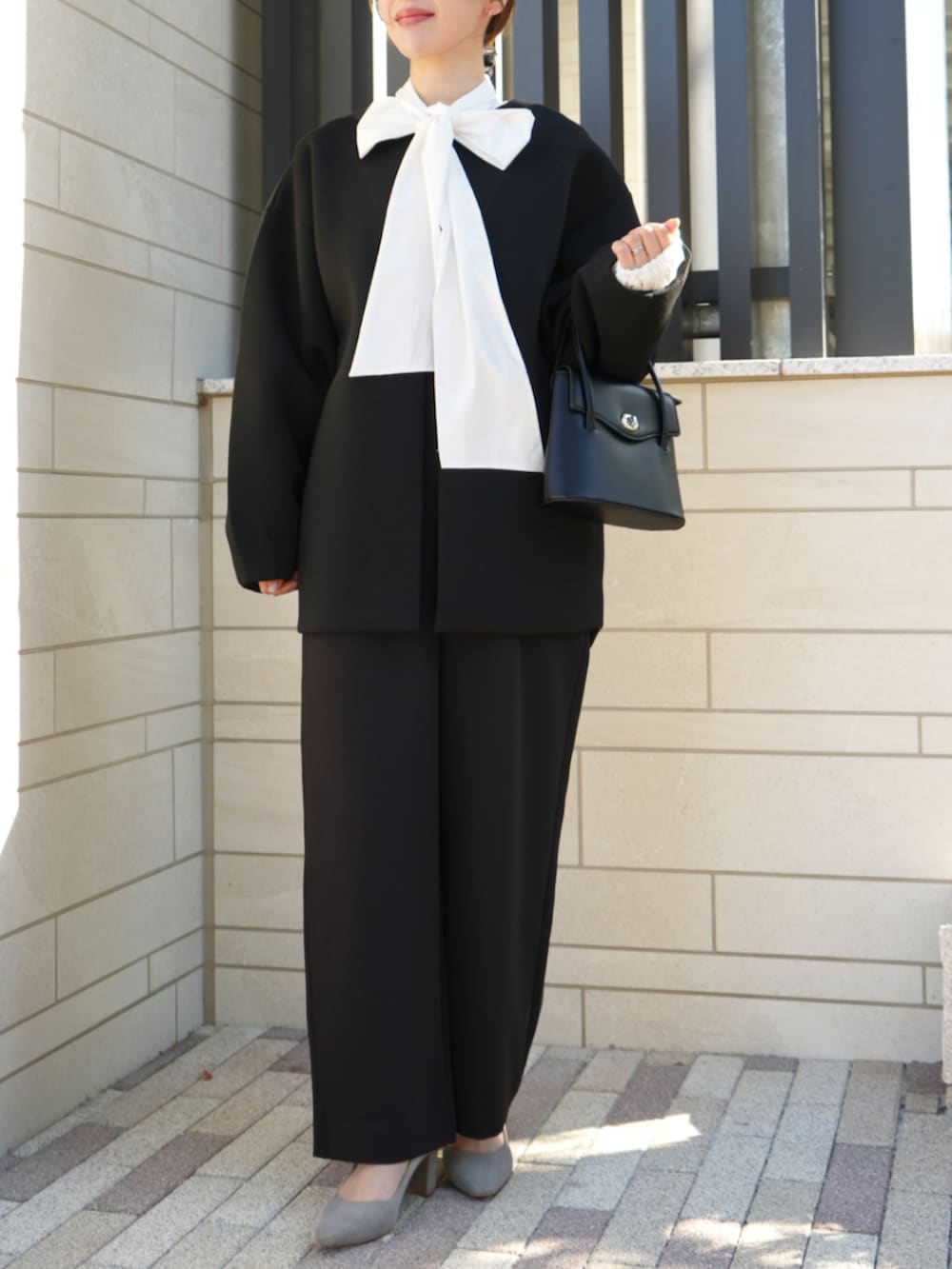 ホワイト系のシャツ/ブラウス、ブラック系のノーカラーコート、ブラック系のつなぎ/オールインワンを着用したレディースの冬コーディネートの2枚目の写真