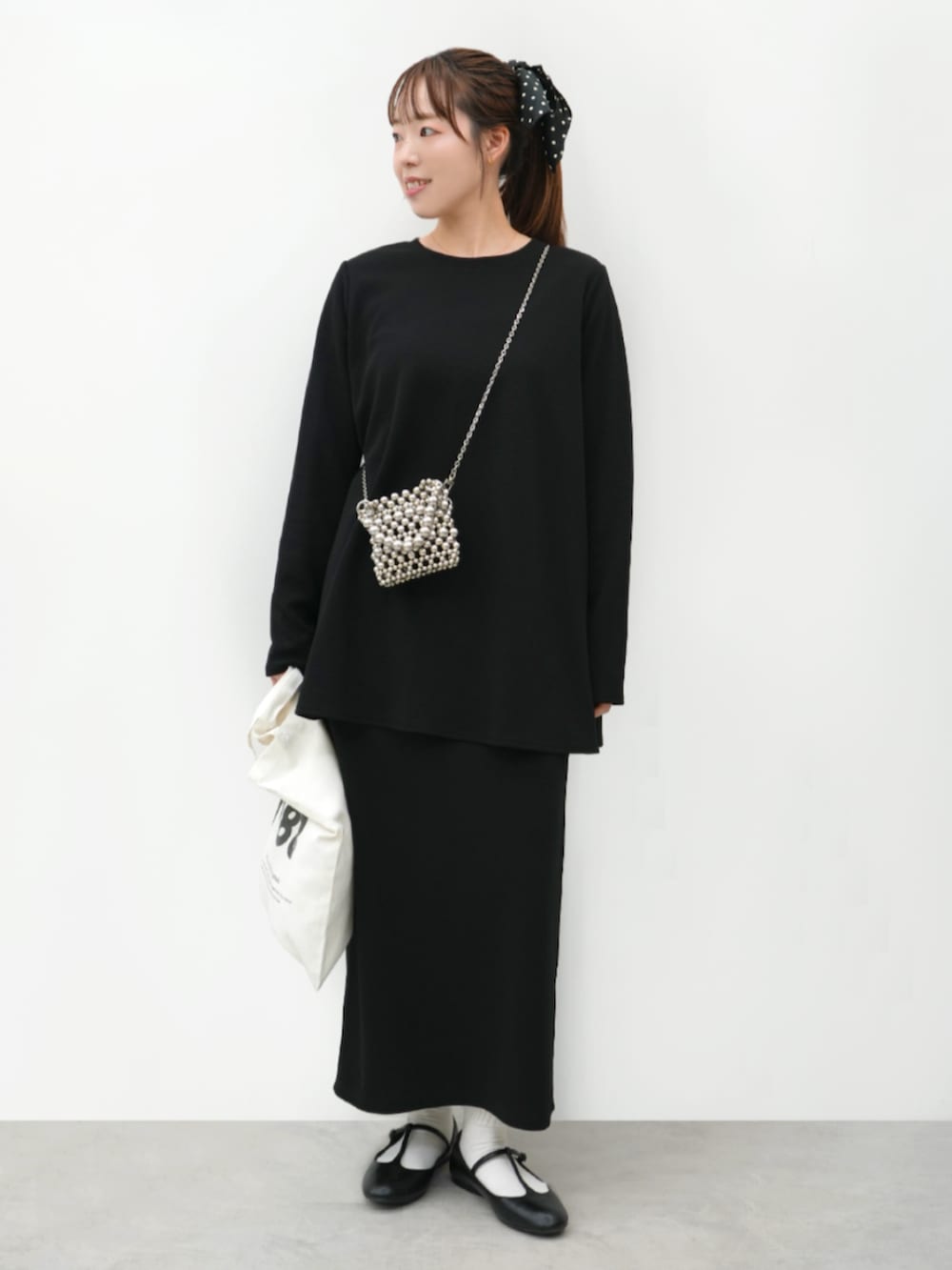 ブラック系のTシャツ/カットソー、ブラック系のスカートを着用したレディースの春コーディネートの3枚目の写真