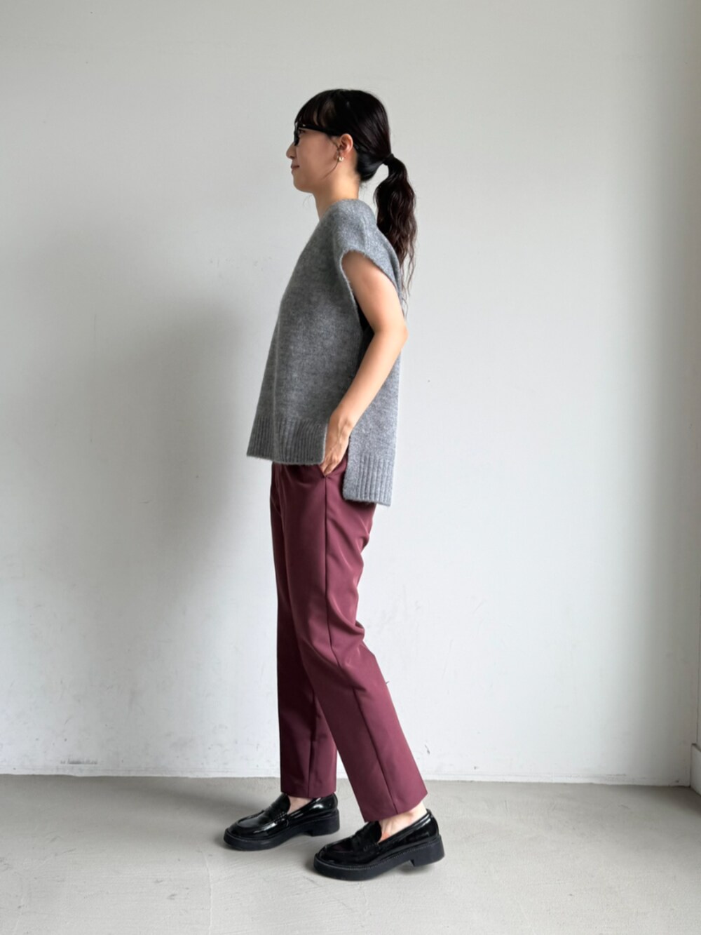 レッド系のスラックスを着用したレディースの夏コーディネートの3枚目の写真