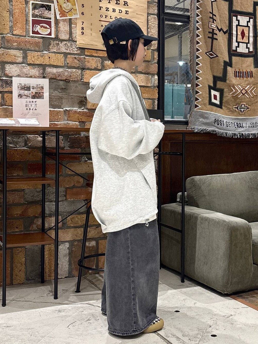 グレー系のパーカーを着用したレディースの秋コーディネートの2枚目の写真