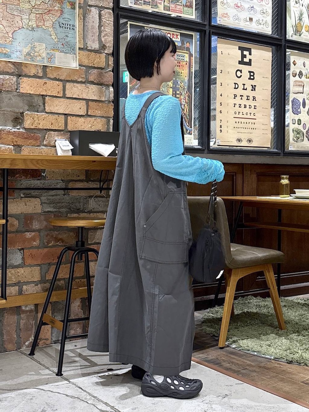 ブラック系のハンドバッグ、ブルー系のTシャツ/カットソー、グレー系のジャンパースカートを着用したレディースの夏コーディネートの8枚目の写真