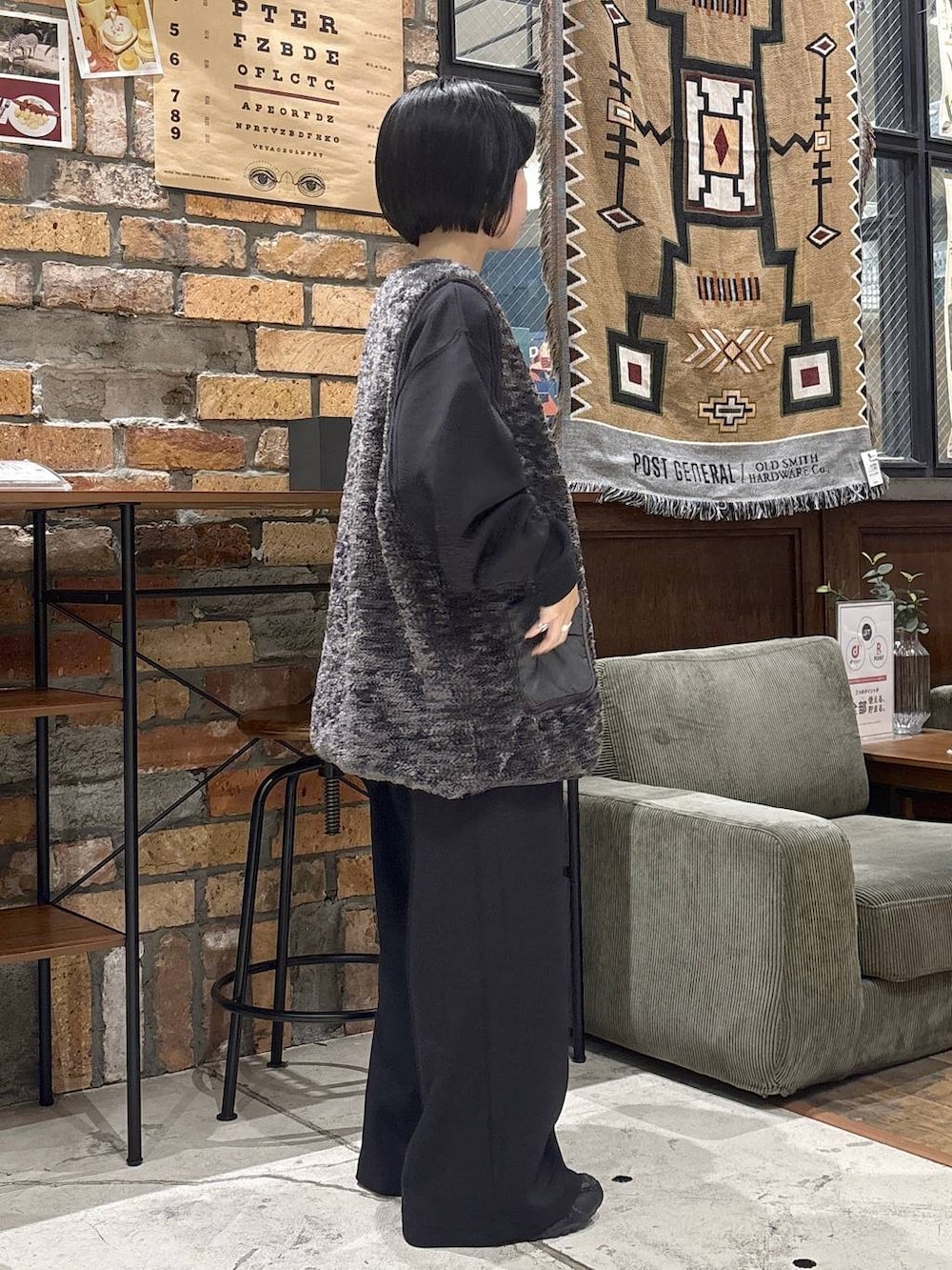 グレー系のベスト、ブラック系のスウェットパンツ、ブラック系のTシャツ/カットソーを着用したレディースの秋コーディネートの4枚目の写真