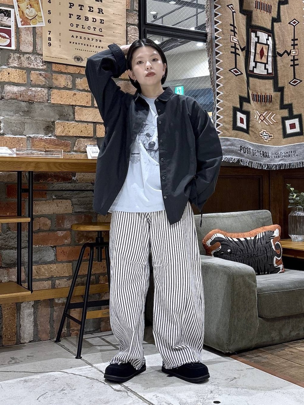 ホワイト系のデニムパンツ、グレー系のシャツ/ブラウス、ブラック系のモカシン/デッキシューズを着用したレディースの春コーディネートの4枚目の写真