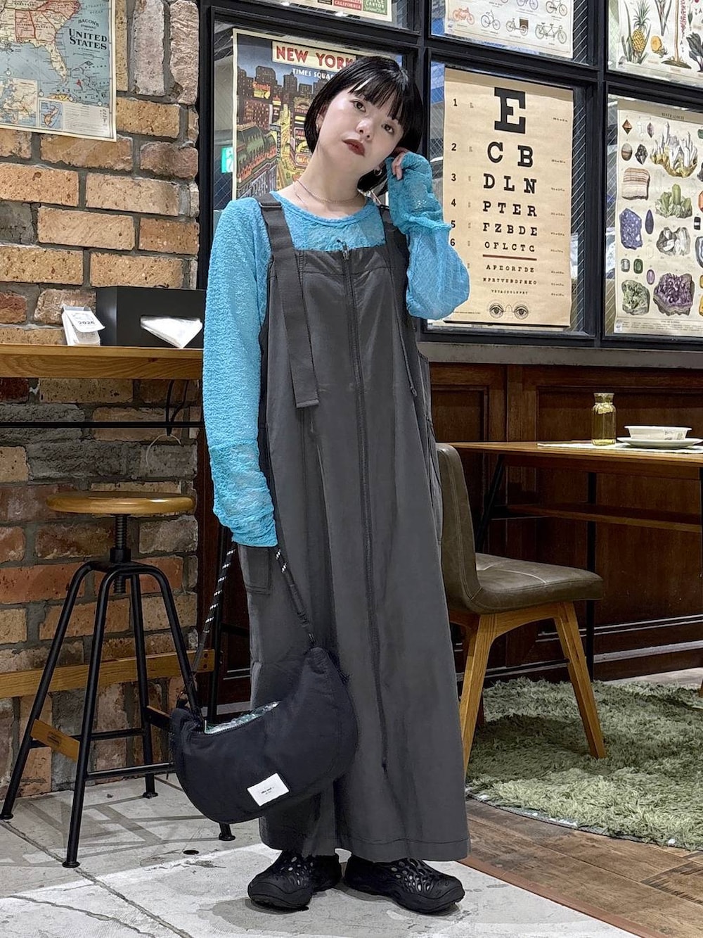 ブラック系のハンドバッグ、ブルー系のTシャツ/カットソー、グレー系のジャンパースカートを着用したレディースの夏コーディネートの7枚目の写真