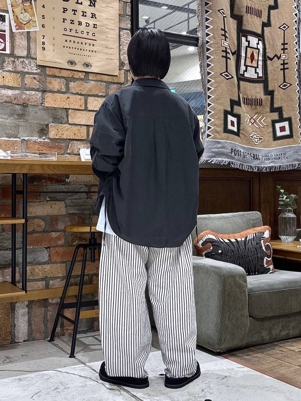 ホワイト系のデニムパンツ、グレー系のシャツ/ブラウス、ブラック系のモカシン/デッキシューズを着用したレディースの春コーディネートの3枚目の写真