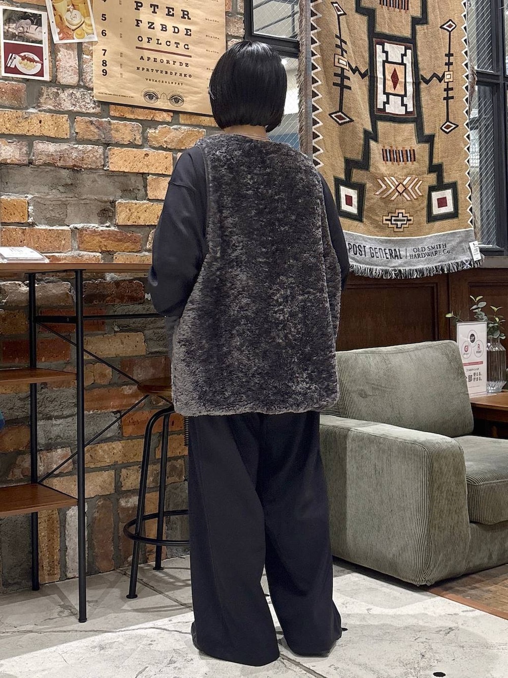 グレー系のベスト、ブラック系のスウェットパンツ、ブラック系のTシャツ/カットソーを着用したレディースの秋コーディネートの3枚目の写真