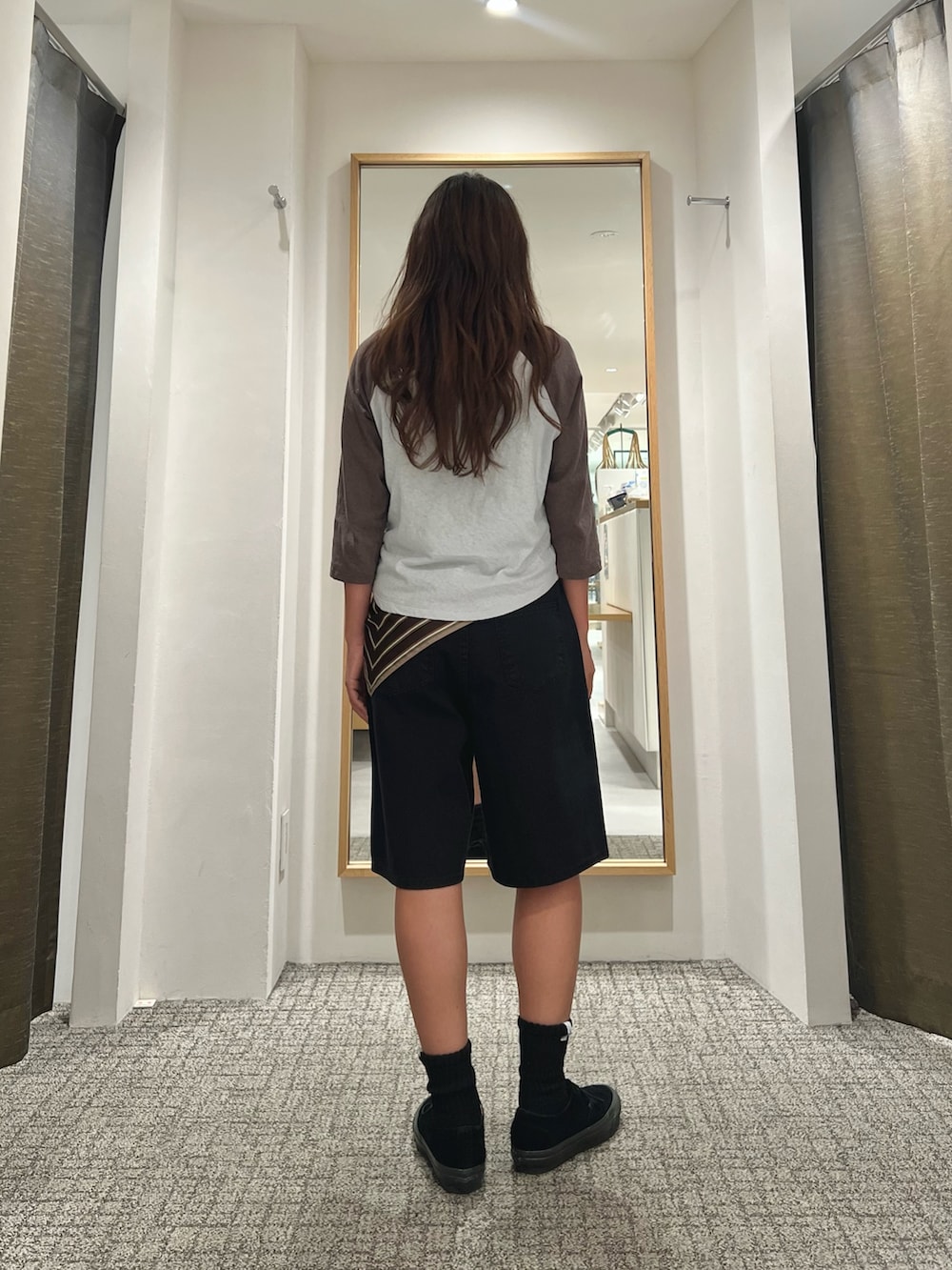 ブラック系のスニーカーを着用したレディースの夏コーディネートの3枚目の写真