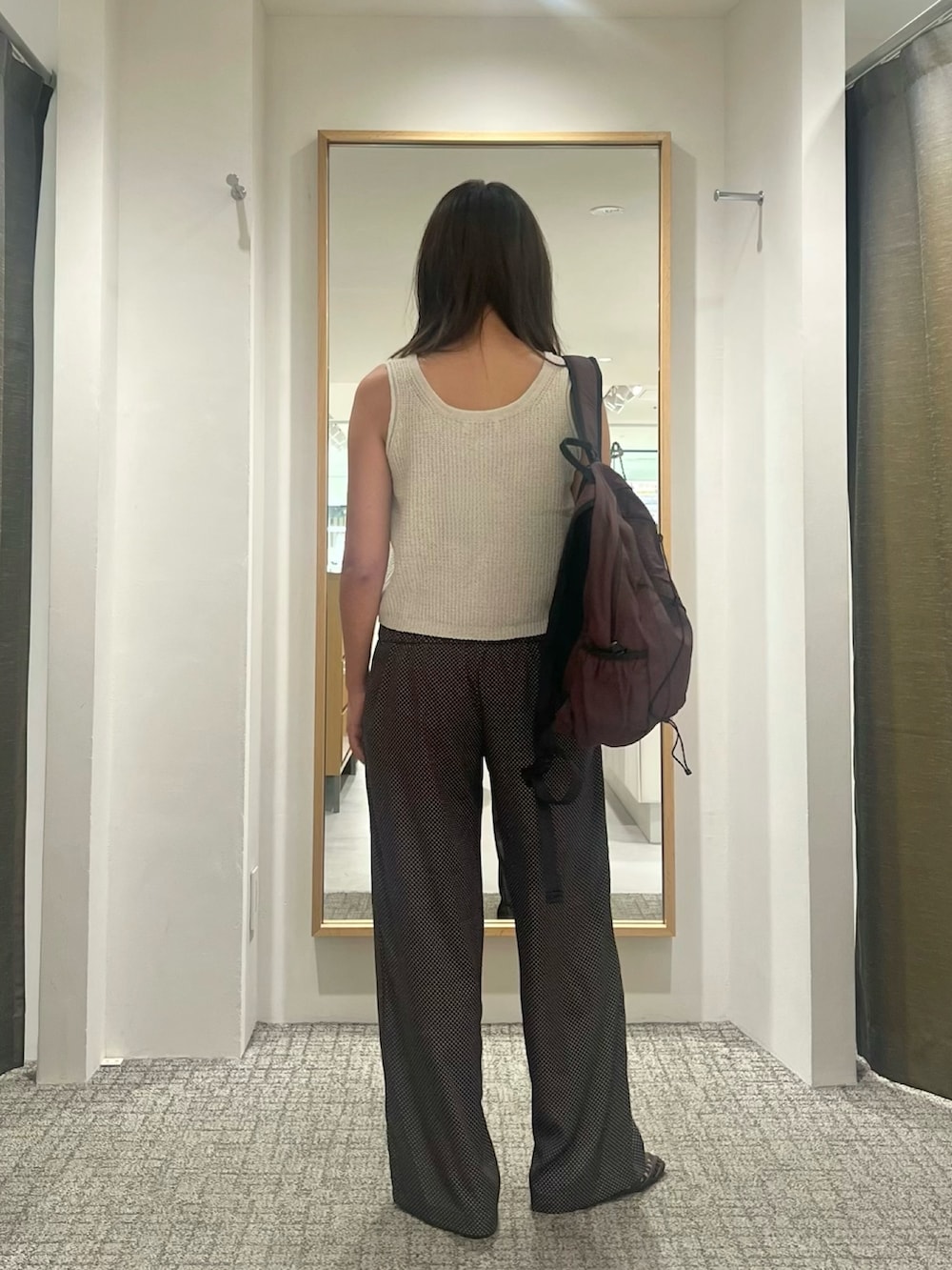 ブラウン系のその他パンツ、ホワイト系のニット/セーター、ブラウン系のバックパック/リュックを着用したレディースの夏コーディネートの3枚目の写真