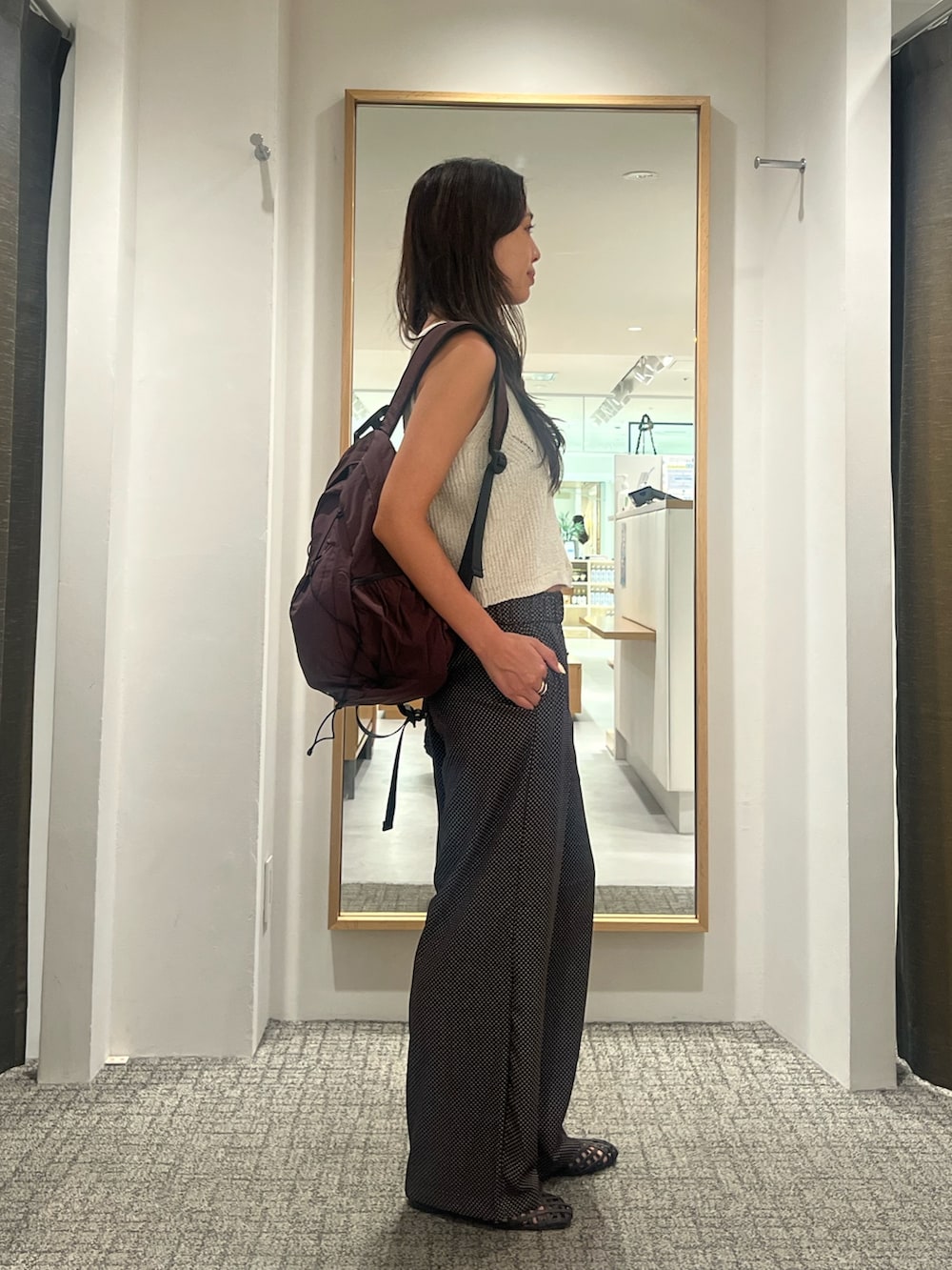 ブラウン系のその他パンツ、ホワイト系のニット/セーター、ブラウン系のバックパック/リュックを着用したレディースの夏コーディネートの2枚目の写真
