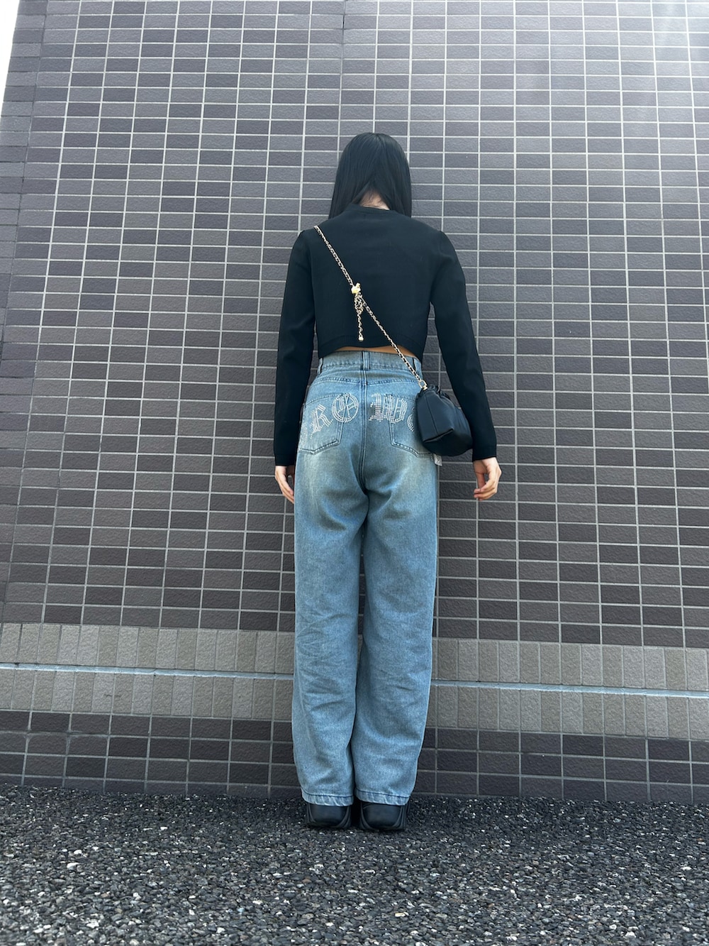 ブラック系のスニーカー、ブルー系のデニムパンツ、ブラック系のカーディガン/ボレロを着用したレディースの春コーディネートの2枚目の写真