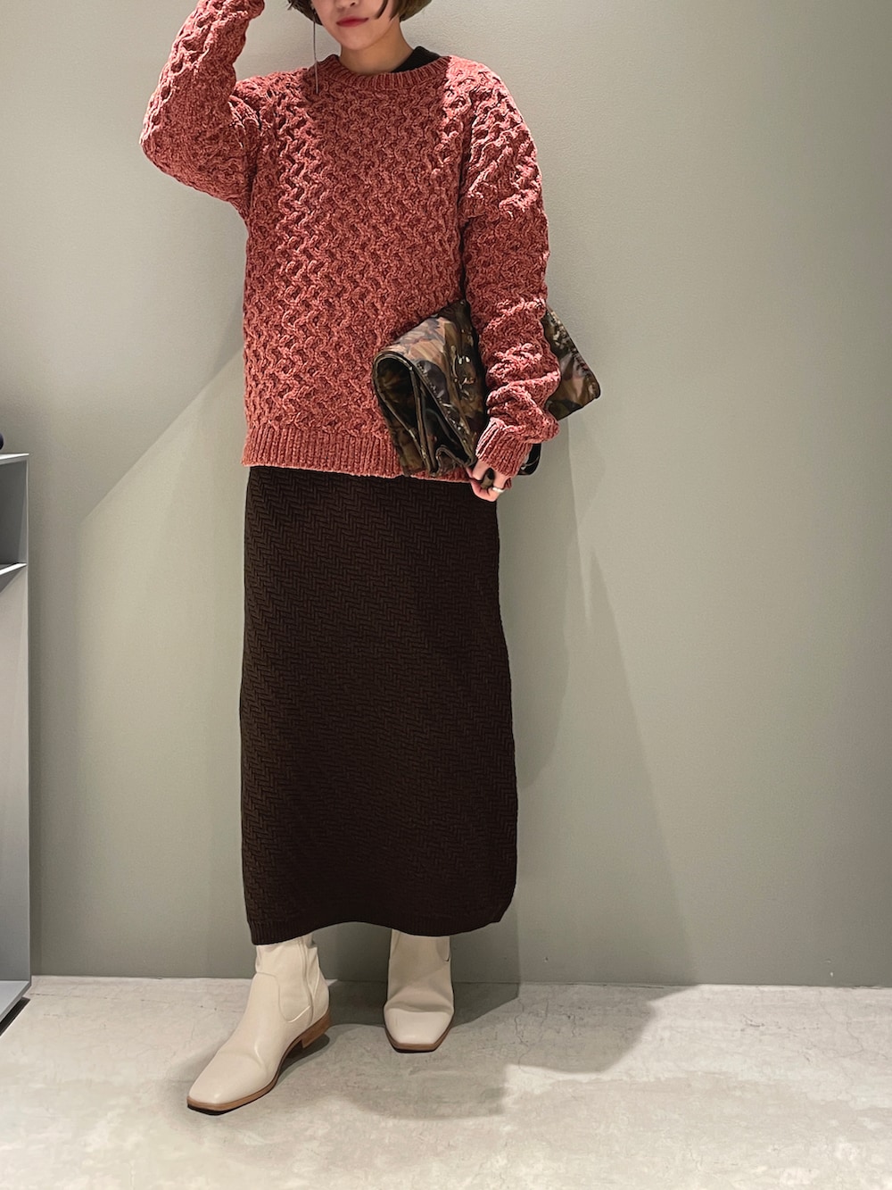 ピンク系のニット/セーター、ブラウン系のワンピース、ベージュ系のトートバッグを着用したレディースの春コーディネートの3枚目の写真