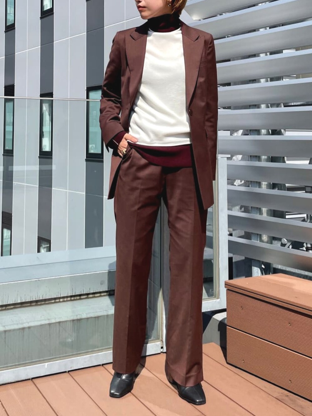 ブラウン系のジャケット/アウター、ホワイト系のニット/セーター、ブラウン系のパンツを着用したレディースの春コーディネートの2枚目の写真