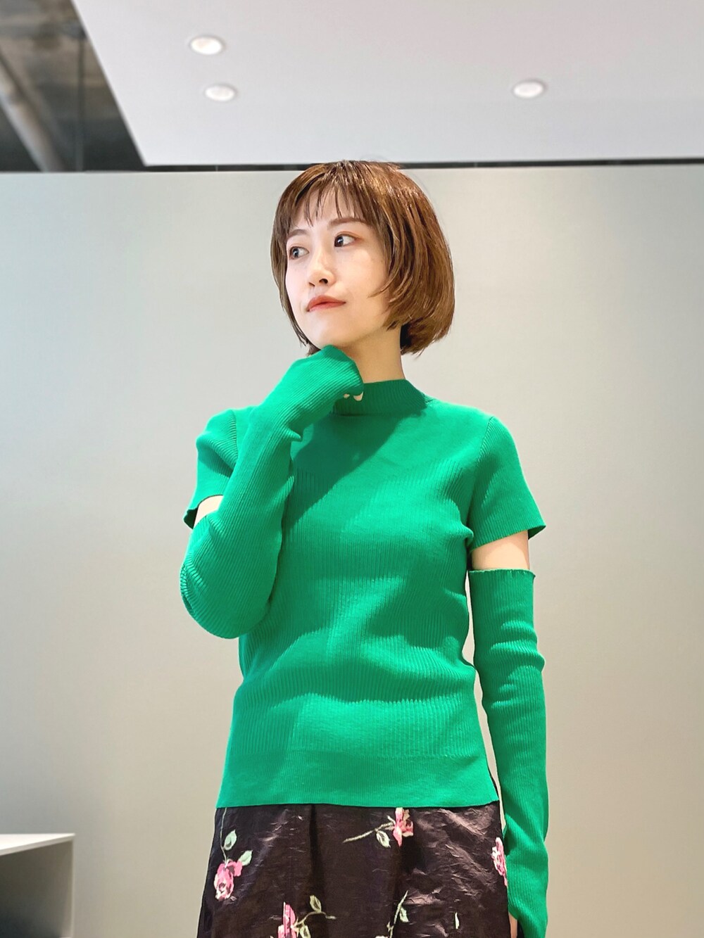 グリーン系のニット/セーター、ブラック系のシューズ、ブラック系のスカートを着用したレディースの春コーディネートの3枚目の写真