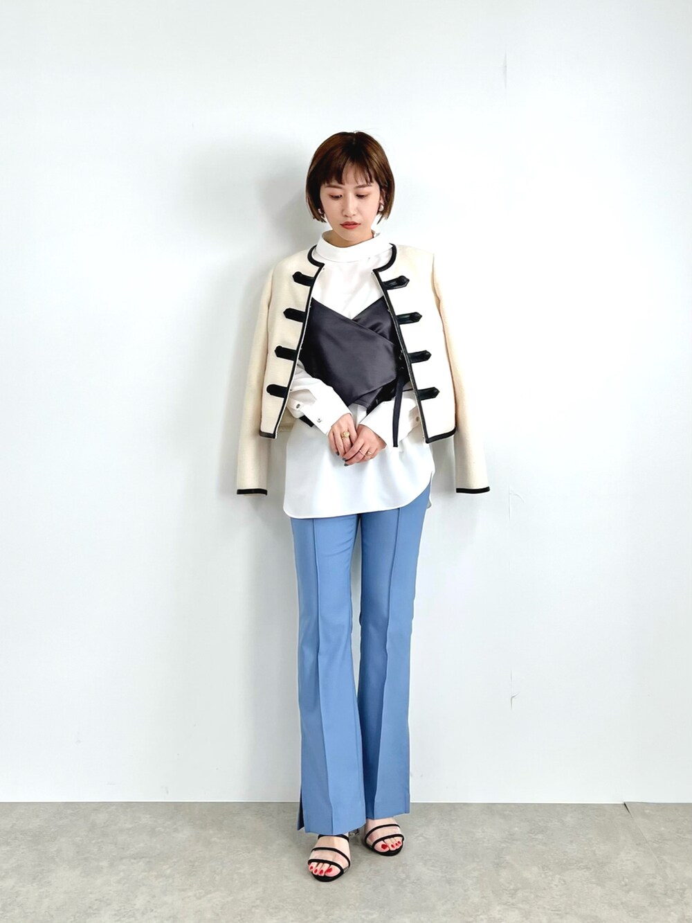 ホワイト系のノーカラージャケット、グレー系のシャツ/ブラウス、ブルー系のその他パンツを着用したレディースの冬コーディネートの2枚目の写真