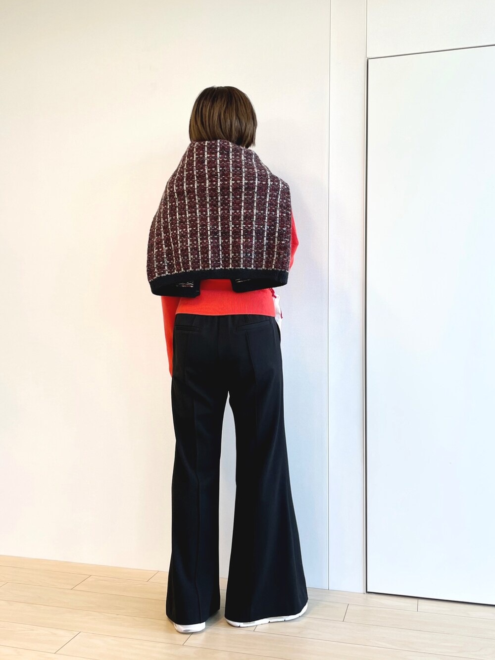 オレンジ系のニット/セーター、ブラック系のその他パンツを着用したレディースの冬コーディネートの3枚目の写真