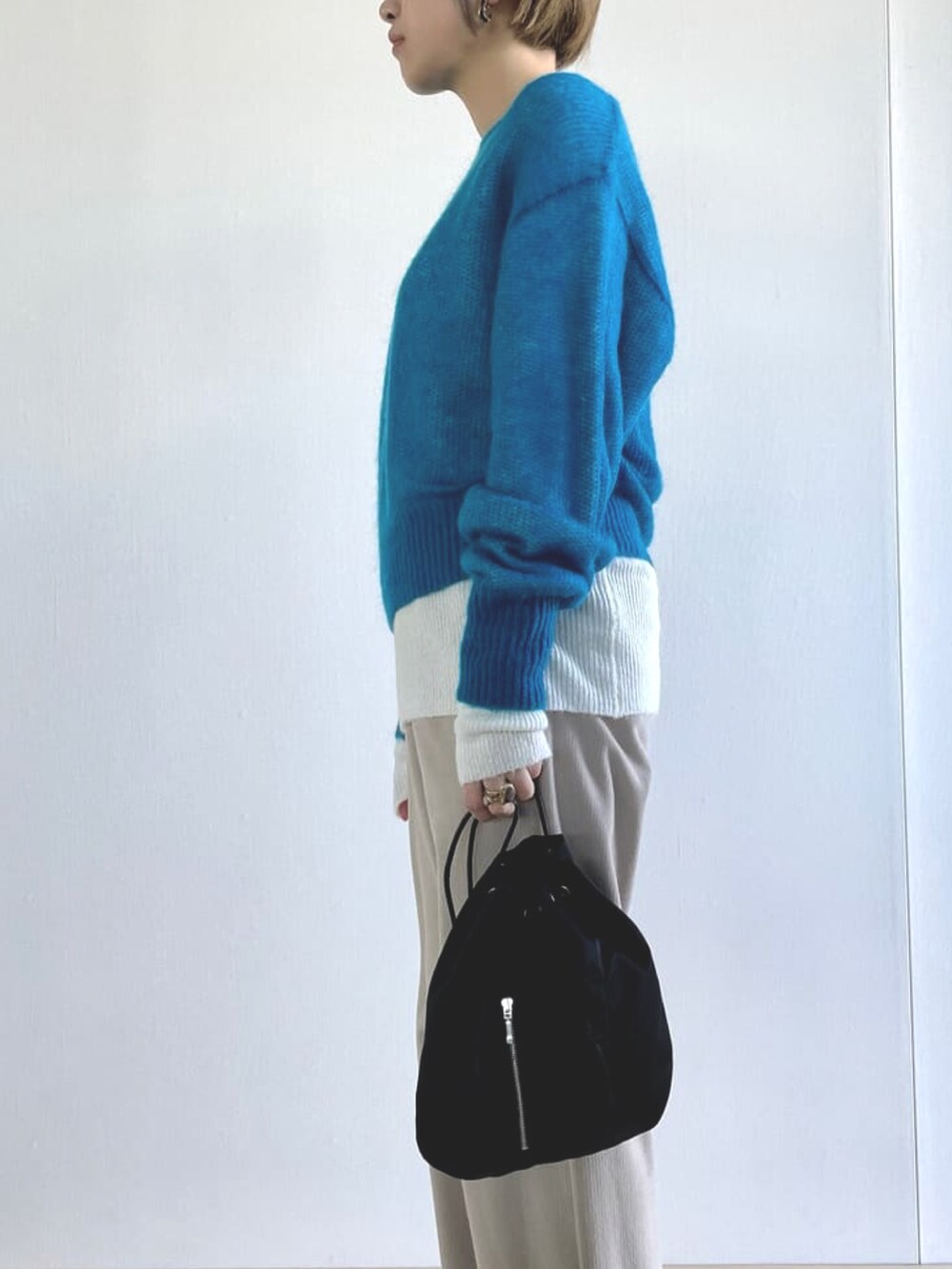ブルー系のニット/セーターを着用したレディースの秋コーディネートの2枚目の写真