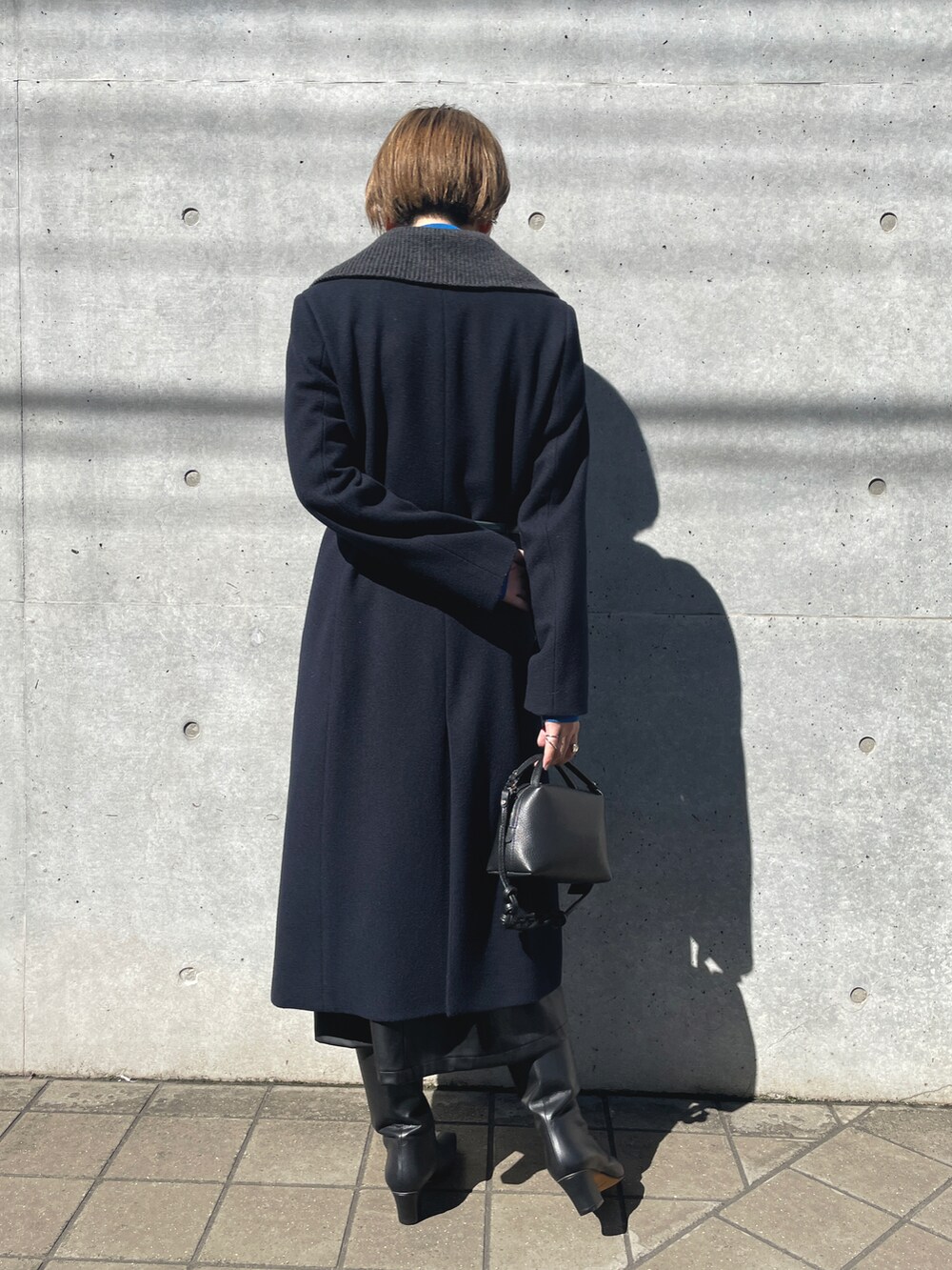 ブルー系のチェスターコート、グレー系のニット/セーター、ブラック系のショルダーバッグを着用したレディースの春コーディネートの5枚目の写真