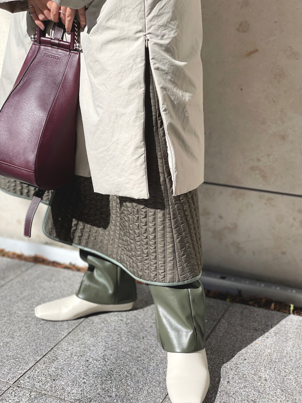 ブラウン系のニット/セーター、ベージュ系のダウンジャケット/コート、グリーン系のその他パンツを着用したレディースの春コーディネートの3枚目の写真