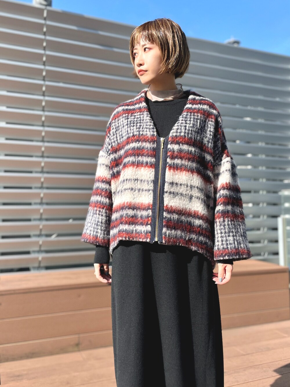 ブルー系のブルゾン、ブラック系のワンピースを着用したレディースの冬コーディネートの2枚目の写真