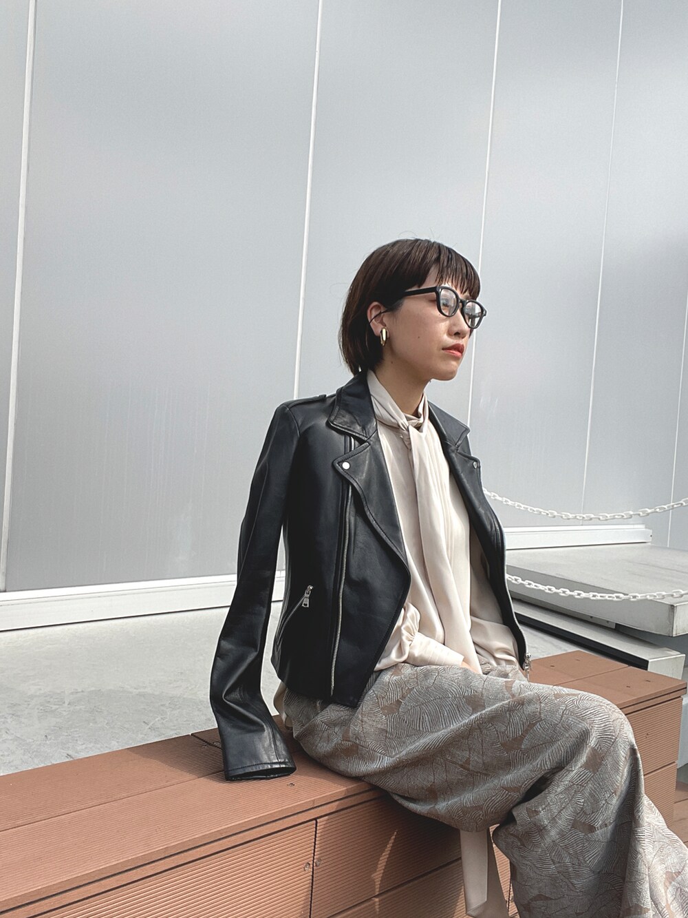 ブラック系のライダースジャケット、ベージュ系のその他パンツを着用したレディースの秋コーディネートの2枚目の写真